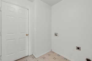 Washroom featuring hookup for a washing machine, light floors, and hookup for an electric dryer