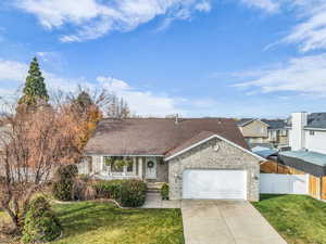 View of front facade with brick siding, a shingled roof, concrete driveway, and a garage