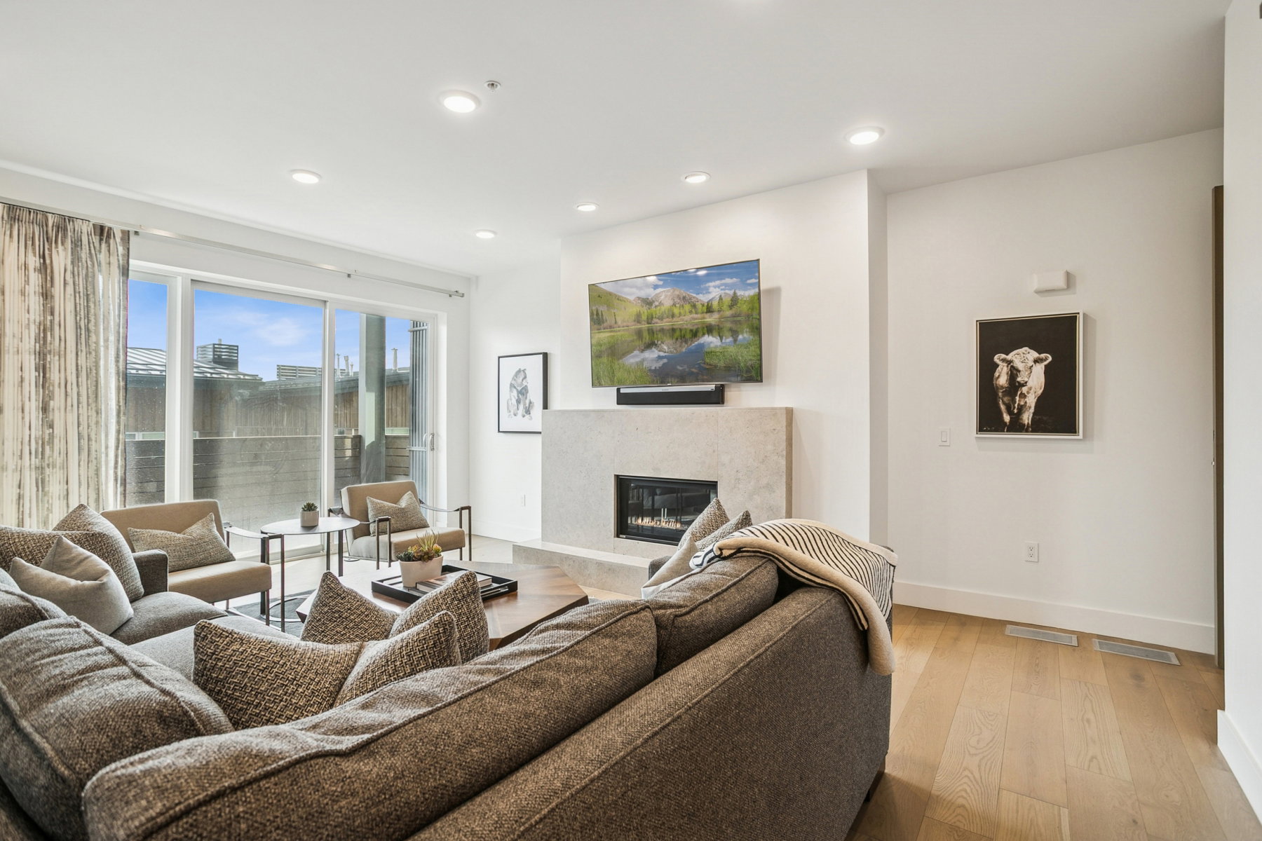 Living area with a premium fireplace, wood finished floors, and recessed lighting