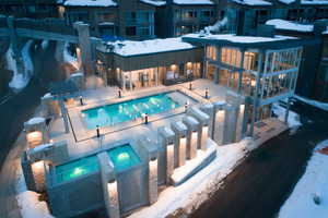 Snow covered pool featuring a community pool, a patio area, a residential view, and a community hot tub