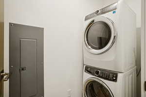 Laundry room with electric panel and stacked washer / drying machine