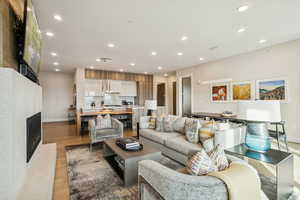 Living room featuring a fireplace, light wood-type flooring, and recessed lighting