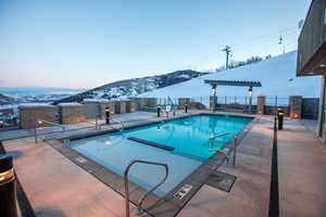 Community pool with a patio area and a mountain view
