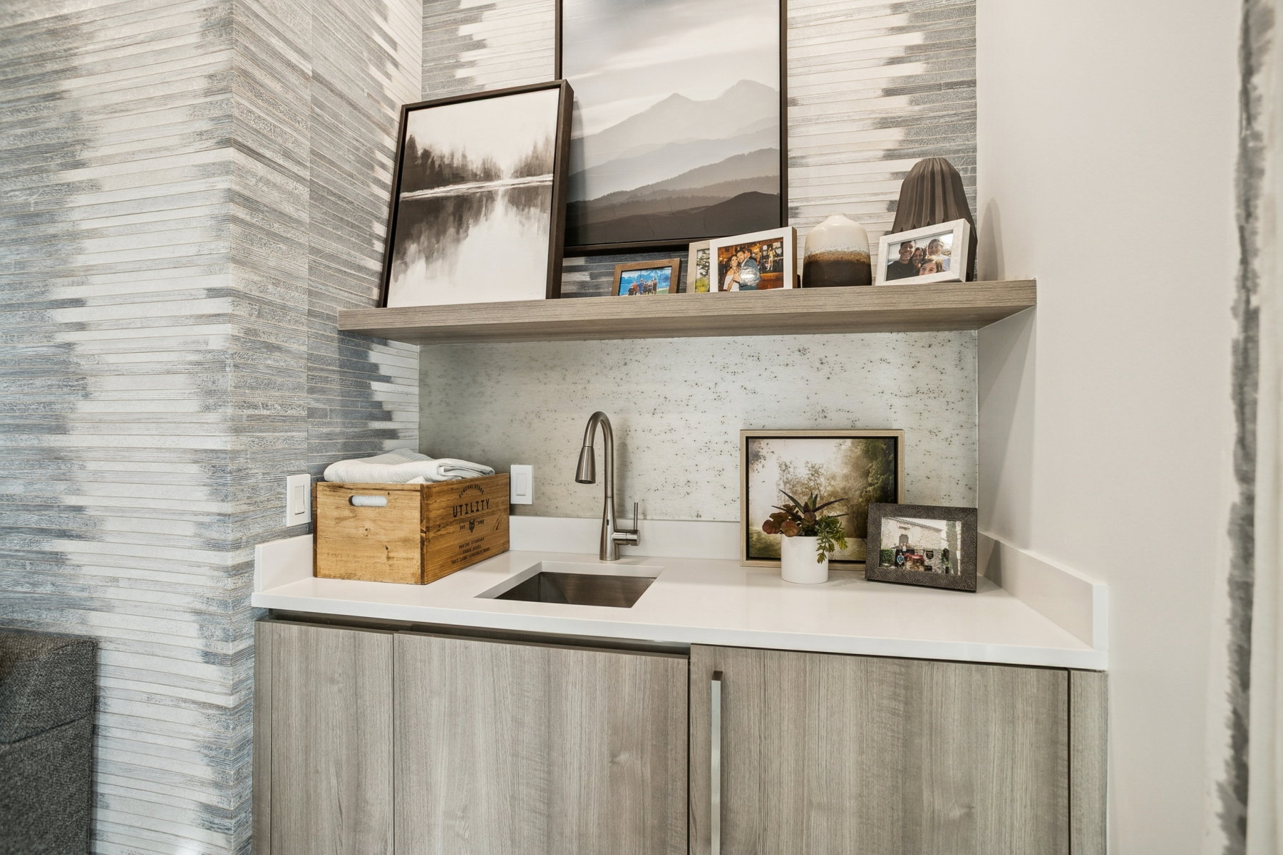 Bar with open shelves, modern cabinets, light brown cabinets, and light stone counters