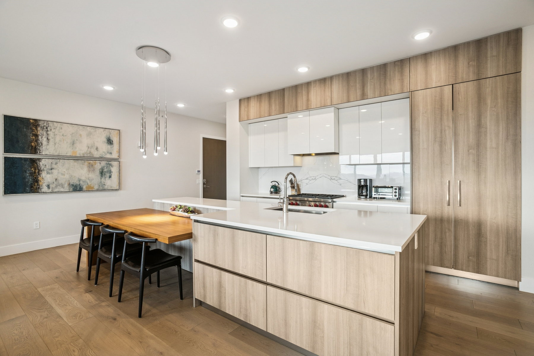 Kitchen with white cabinetry, light wood-type flooring, an island with sink, backsplash, and modern cabinets