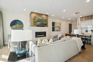 Living area with light wood finished floors, recessed lighting, and a large fireplace