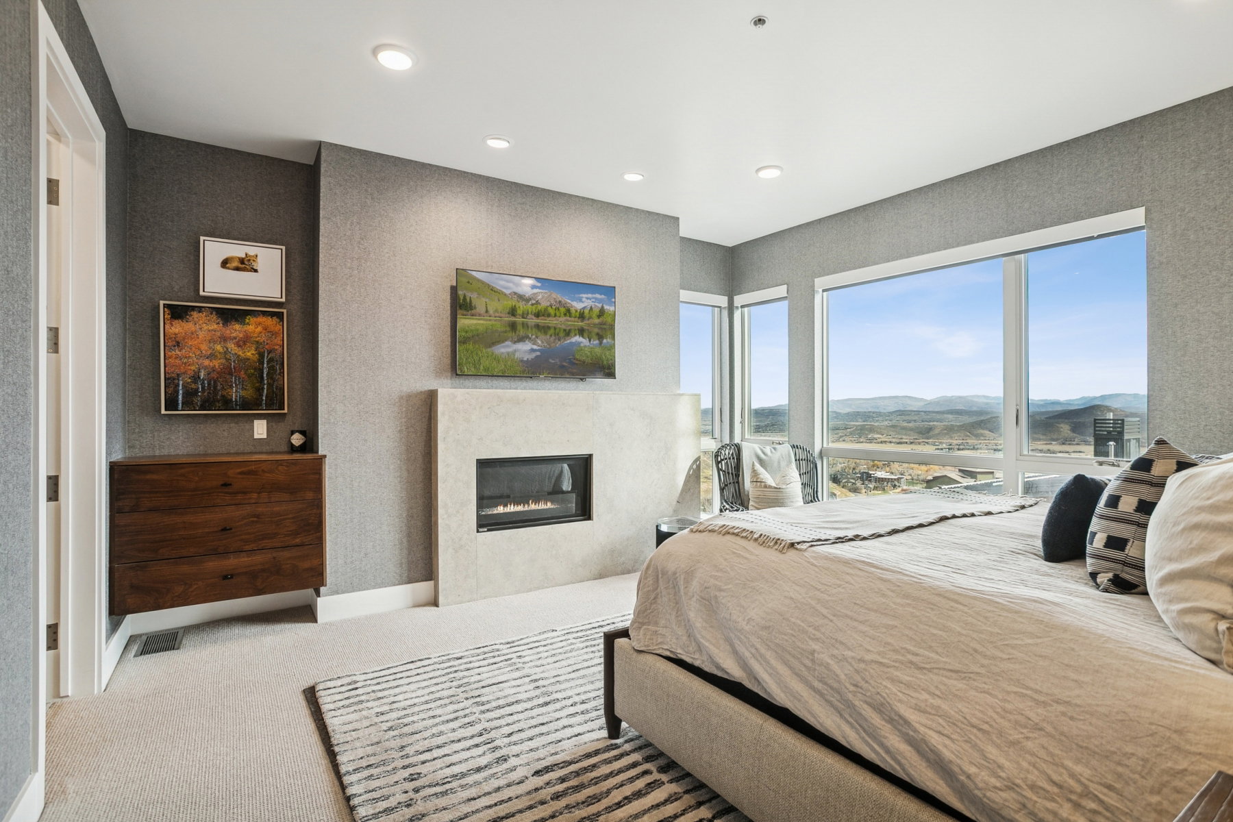 Carpeted bedroom featuring a glass covered fireplace and recessed lighting