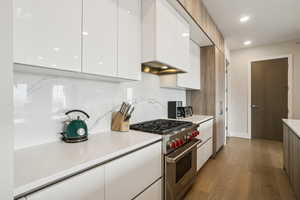 Kitchen with white cabinets, premium stove, modern cabinets, dark wood-style floors, and recessed lighting