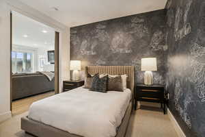 Bedroom featuring wallpapered walls, recessed lighting, light carpet, and an accent wall