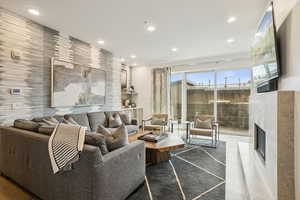 Living area with a lit fireplace, recessed lighting, and an accent wall