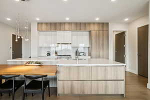 Kitchen featuring white cabinetry, recessed lighting, light wood-style floors, a large island with sink, and tasteful backsplash