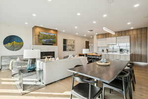 Dining room with light wood finished floors, a fireplace, and recessed lighting
