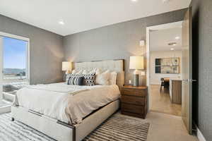 Bedroom with wallpapered walls, recessed lighting, and light carpet