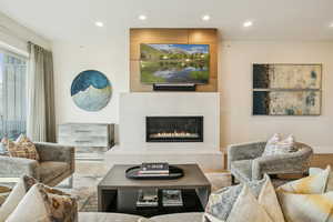 Living area with recessed lighting, wood finished floors, and a large fireplace