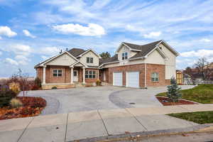 View of front of property featuring concrete driveway, stucco siding, brick siding, a shingled roof, and an attached garage