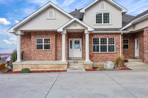 View of front of house with brick siding and roof with shingles