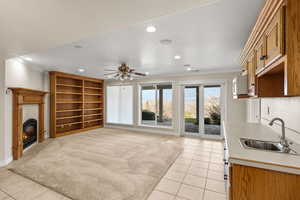 Unfurnished living room with ornamental molding, a tiled fireplace, light tile patterned floors, recessed lighting, and a ceiling fan