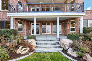 Property entrance featuring brick siding and a patio