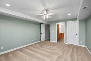 Unfurnished bedroom with recessed lighting, light carpet, ensuite bath, and a ceiling fan