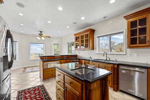 Kitchen featuring glass insert cabinets, a kitchen island with sink, stainless steel appliances, plenty of natural light, and recessed lighting