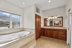 Full bathroom featuring vanity, a bath, light tile flooring, and recessed lighting