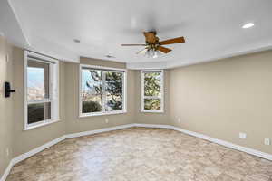 Empty room featuring baseboards and a ceiling fan