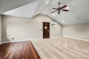 Unfurnished living room with lofted ceiling, wood finished floors, recessed lighting, and a ceiling fan