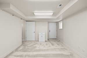 Unfurnished bedroom with carpet, a raised ceiling, and a textured ceiling