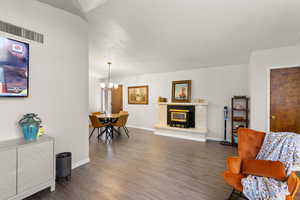 Sitting room with dark wood finished floors, a chandelier, and a premium fireplace