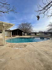 Community pool with a patio and a sunroom