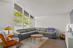Living room with wood finished floors and vaulted ceiling