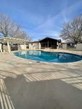 Community pool with a patio area and a pergola