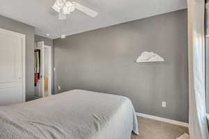Carpeted bedroom featuring a ceiling fan and a closet