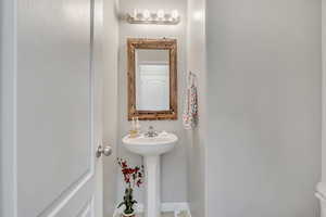 Half bath featuring toilet and baseboards