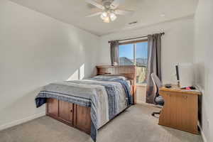 Bedroom featuring carpet floors, a ceiling fan, and a desk