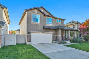 View of front of home with stucco siding, an attached garage, driveway, and brick siding