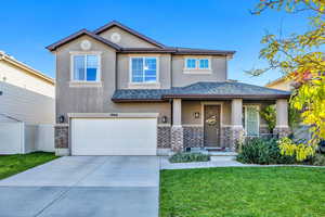 View of front of house featuring stucco siding, a garage, a porch, concrete driveway, and brick siding