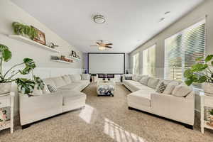 Carpeted living room featuring ceiling fan