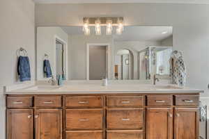 Bathroom featuring double vanity and a shower stall