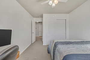 Bedroom with carpet floors, a closet, and a ceiling fan