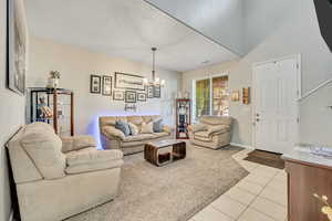 Living area featuring light tile patterned floors and a chandelier