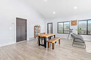 Dining space featuring high vaulted ceiling, recessed lighting, light wood-type flooring, and a mountain view