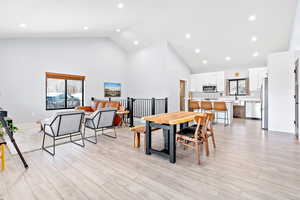 Dining room featuring recessed lighting, high vaulted ceiling, and light wood-type flooring