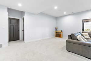 Living area with recessed lighting and light colored carpet