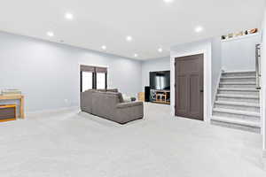 Living room with recessed lighting, carpet, and stairway