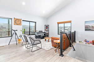 Living area featuring recessed lighting, light wood finished floors, high vaulted ceiling, and a mountain view