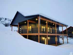 View of snowy exterior featuring a large porch