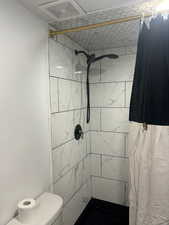 Full bathroom featuring a stall shower and toilet