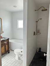 Master Full bathroom with vanity, a freestanding bath, tiled shower, and light tile patterned flooring