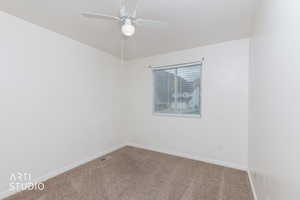 Carpeted spare room with baseboards and a ceiling fan